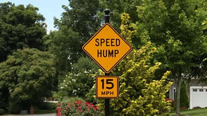 AOD speed hump and 15 MPH signs on a decorative post