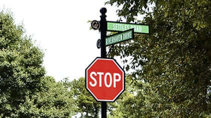 AOD street name blades above a stop sign on one decorative post